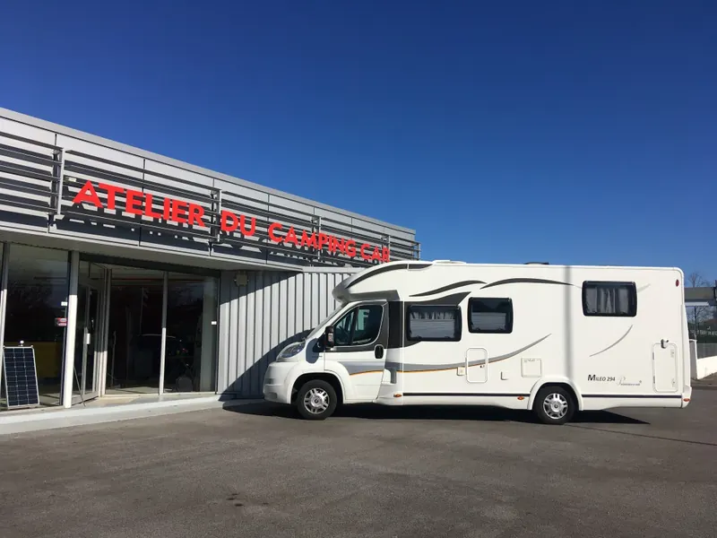 Camping-car stationné devant l'Atelier du camping car à Dax, par grand ciel bleu